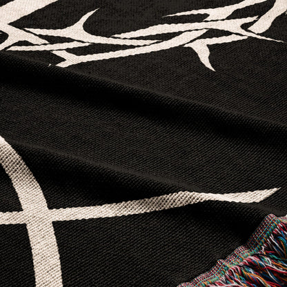 Black fabric with white tribal-like pattern and fringed edge.