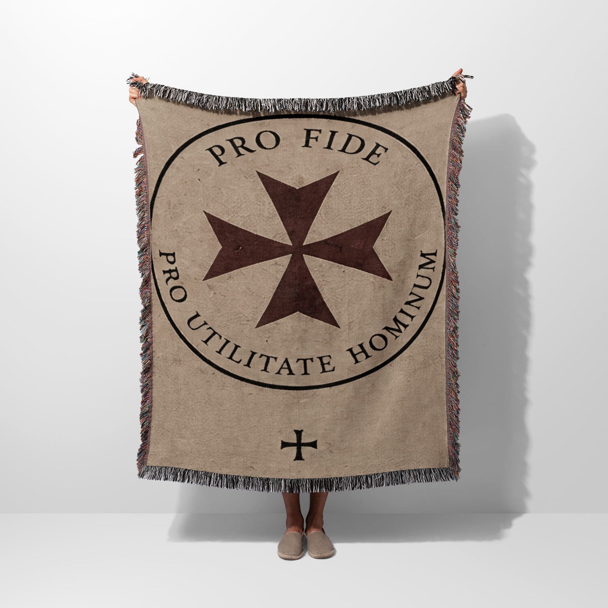 Woven blanket with central cross emblem and Latin text "Pro Fide Utilitate Hominum."