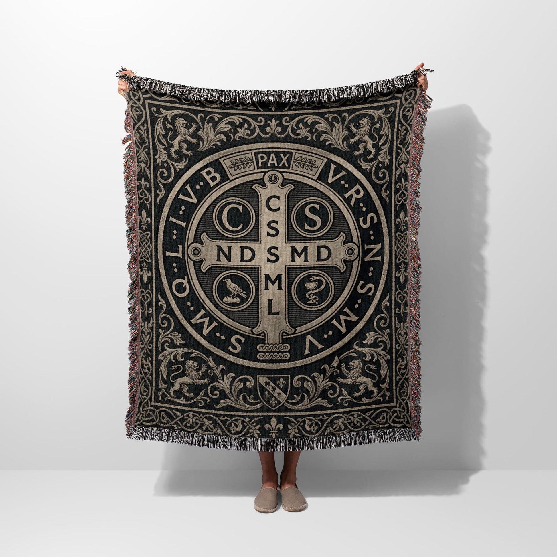 Woven blanket featuring a St. Benedict medal design with ornate border.