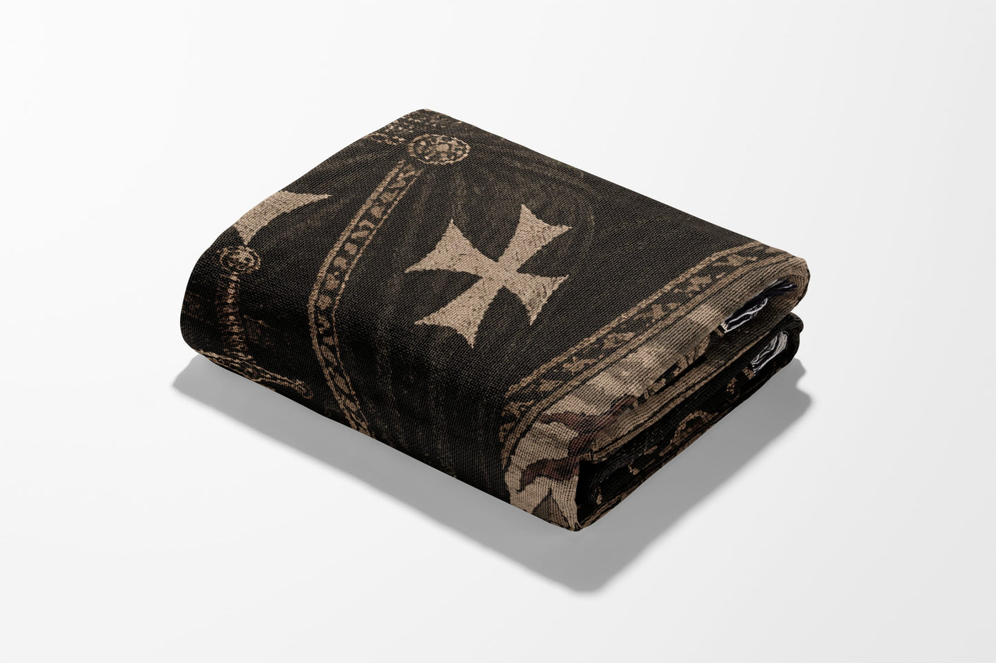Folded dark tapestry featuring a large cream-colored cross and ornate border.