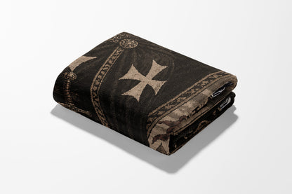 Folded dark tapestry featuring a large cream-colored cross and ornate border.