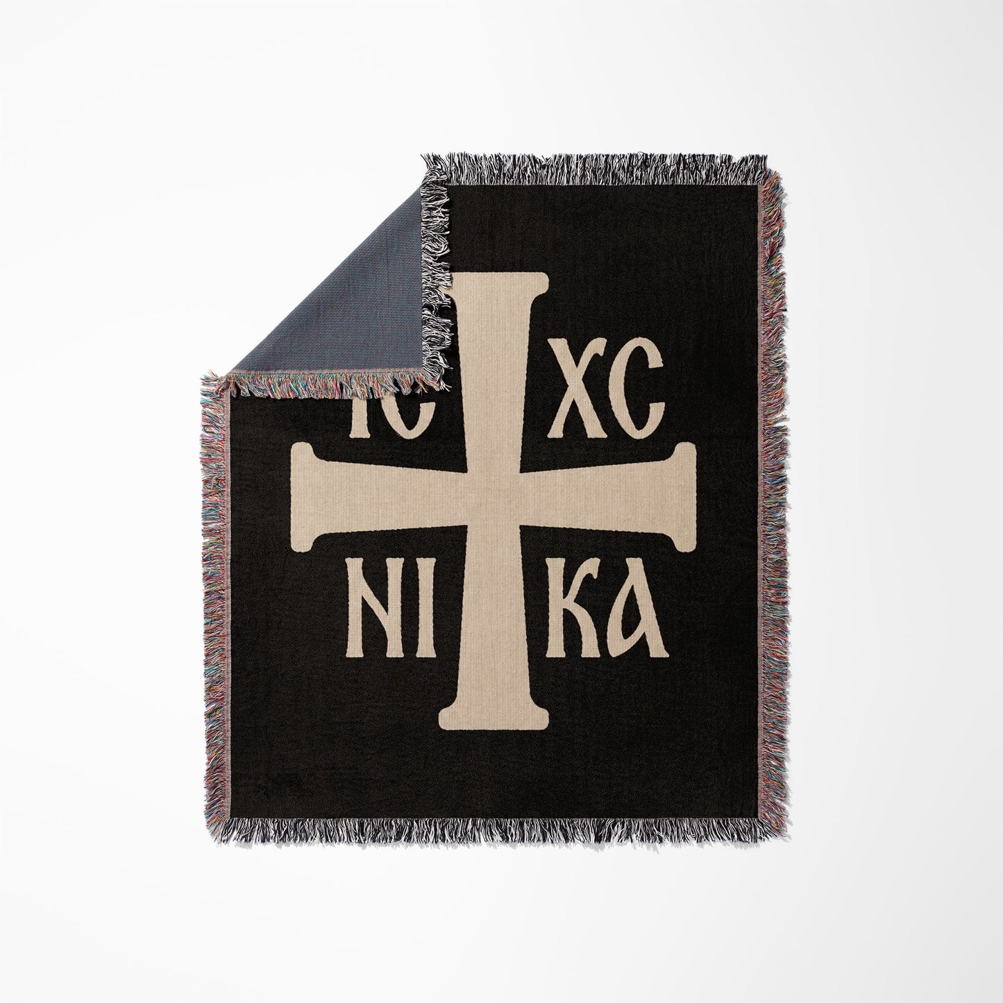 Black throw blanket with beige Byzantine cross and Greek text.