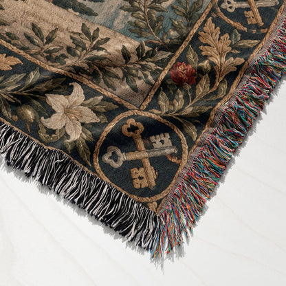 A woven tapestry blanket with a floral and crossed keys design, featuring multicolored fringe borders.