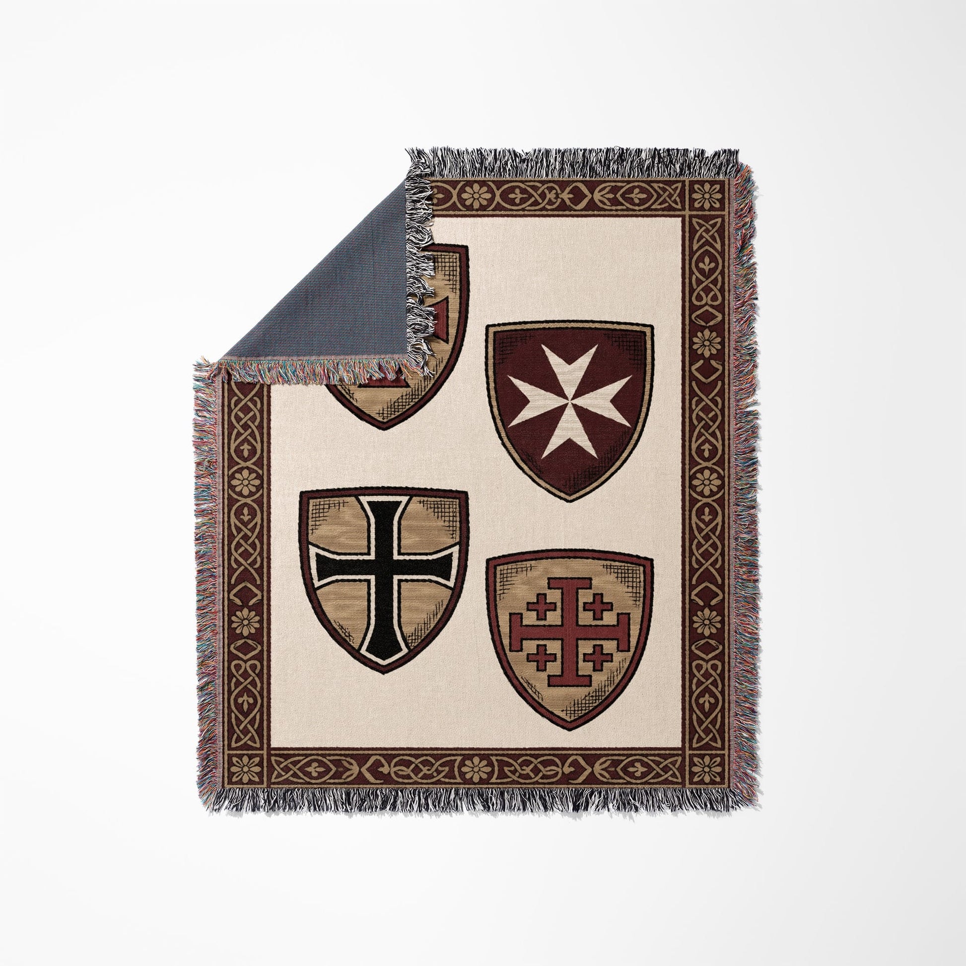Woven blanket featuring four medieval shields with ornate border and fringe.