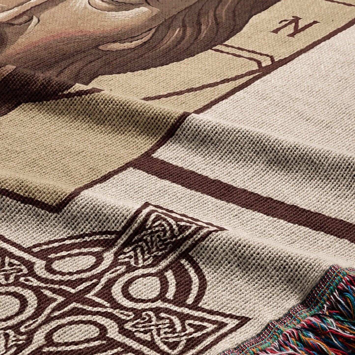 Close-up of a woven tapestry with Celtic knot designs and a partial human face.