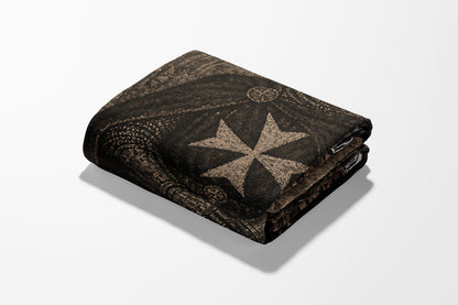 Folded brown blanket with a Maltese cross pattern.