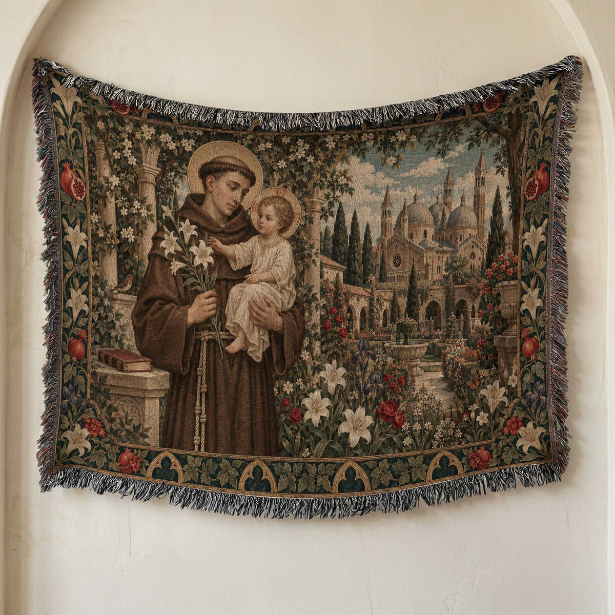 Woven tapestry wall hanging featuring Saint Anthony holding the Christ Child amid gardens and buildings.