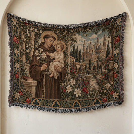 Woven tapestry wall hanging featuring Saint Anthony holding the Christ Child amid gardens and buildings.