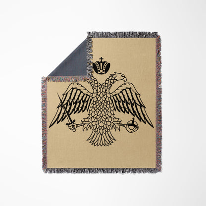 Black double-headed eagle crest with crown, sword, and scepter on a beige blanket.