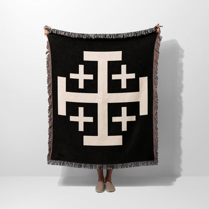 Black throw blanket with a large cream geometric cross pattern.