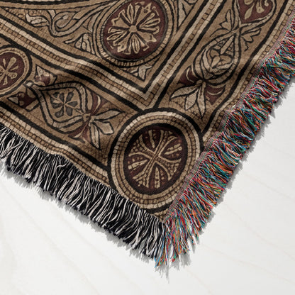 Woven blanket with geometric and floral patterns, and fringed edges.