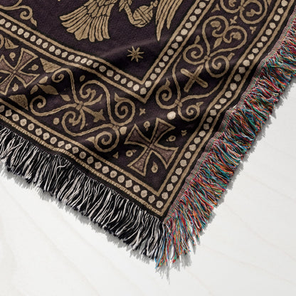 Brown tapestry blanket with ornate gold patterns and colorful fringe.
