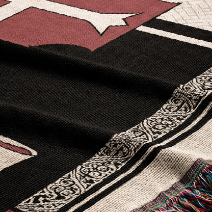 Black and white patterned throw blanket with tasseled edge and maroon design.