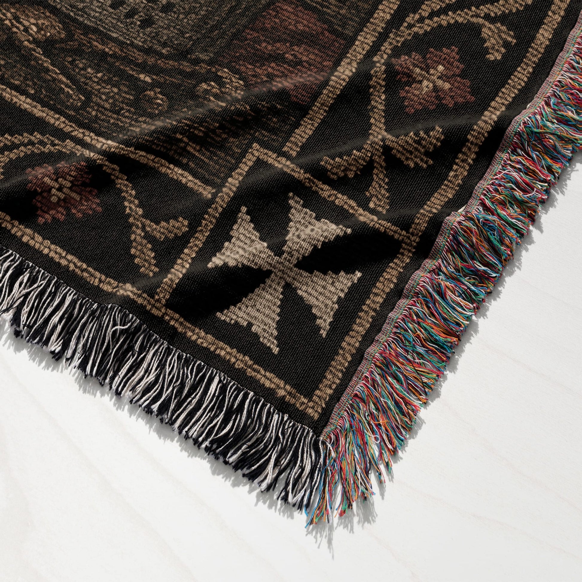 Woven throw blanket with cross pattern and colorful fringe.