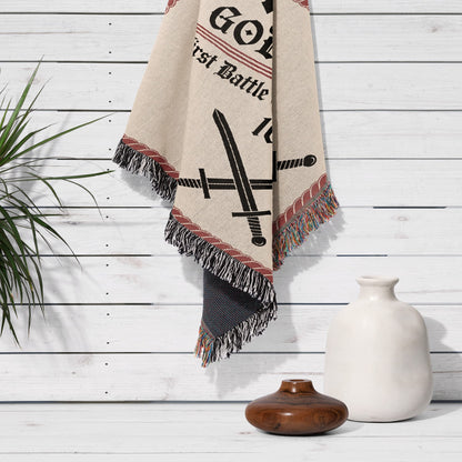 Woven throw blanket with crossed swords and "First Battle" text.