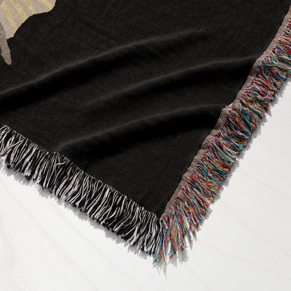Black woven throw blanket with fringed edge in multiple colors.