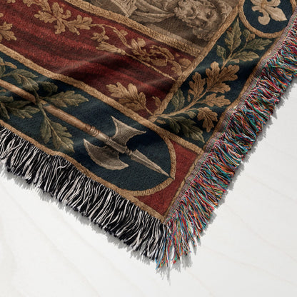 Folded woven throw blanket with medieval-style heraldic patterns, oak leaf borders, and colorful fringe edges.