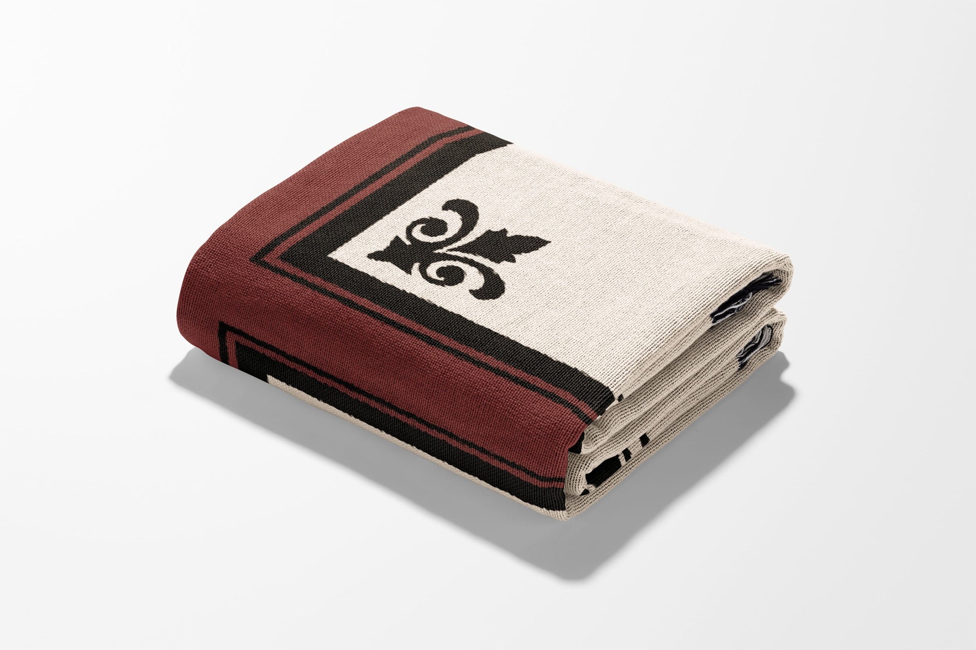 Folded blanket with a cream field and dark red border featuring a black fleur-de-lis.