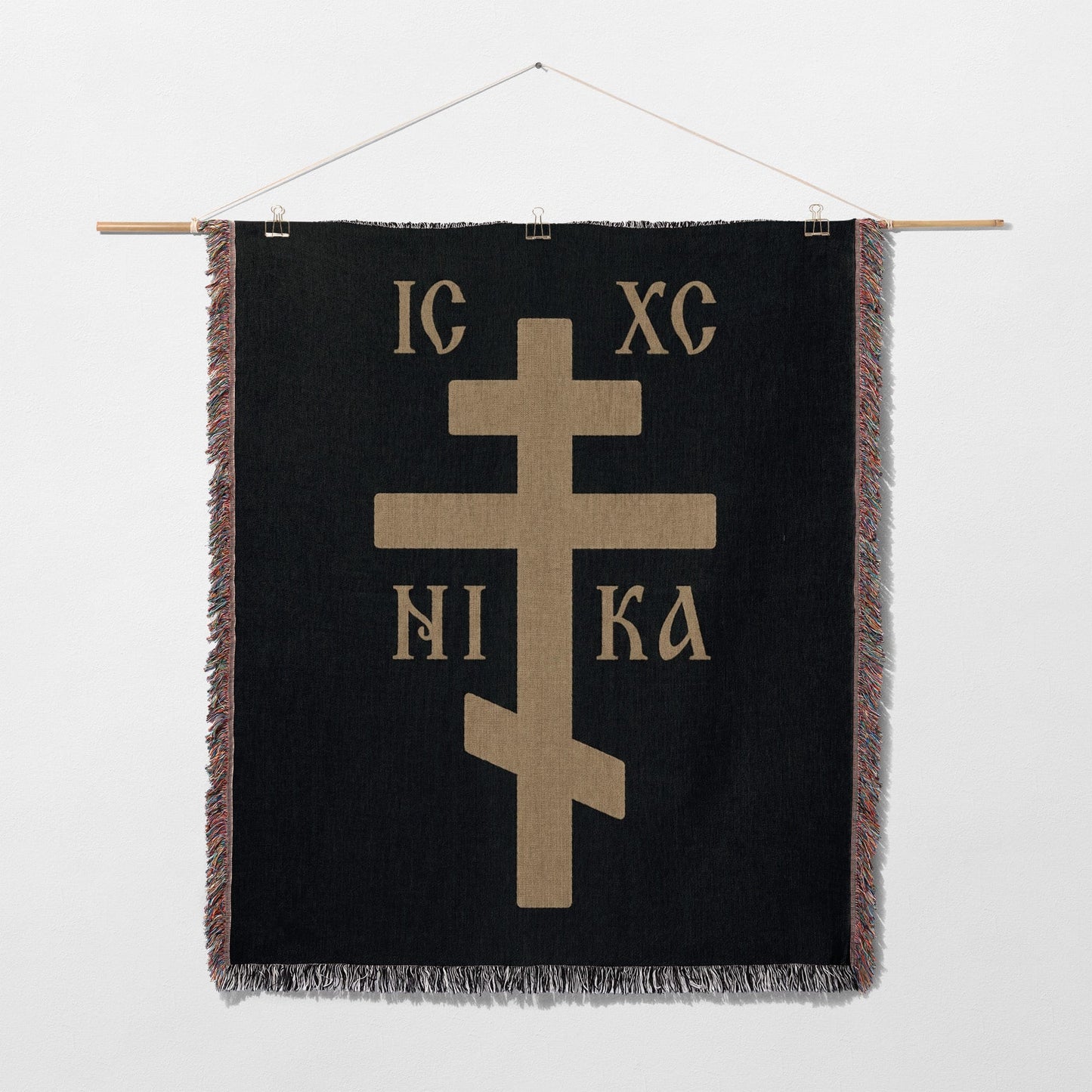 Black tapestry wall hanging with a gold Orthodox cross and Greek text IC XC NIKA.