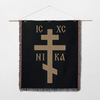 Black tapestry wall hanging with a gold Orthodox cross and Greek text IC XC NIKA.