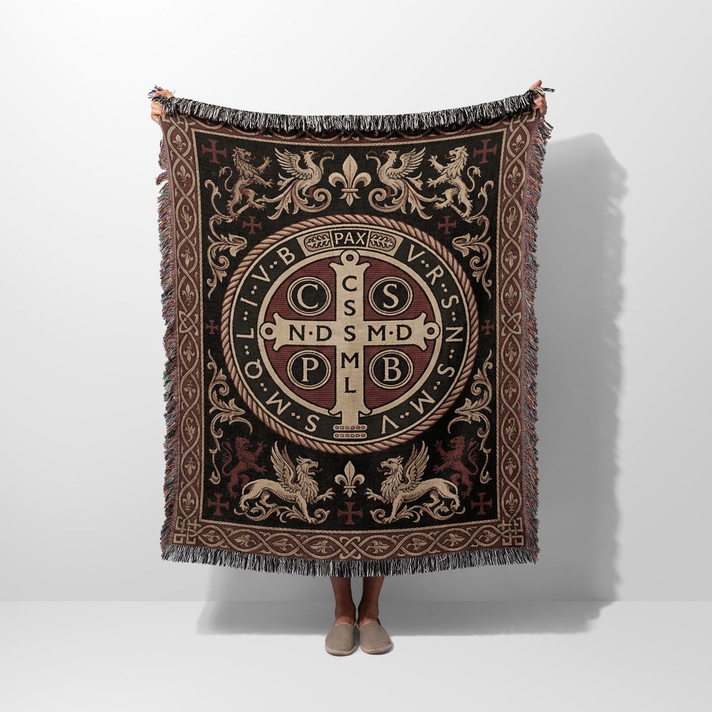 Tapestry throw with St. Benedict medal design, fringe, and medieval motifs.