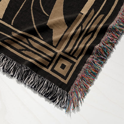 Black and tan woven throw blanket with fringed edges, featuring geometric pattern.