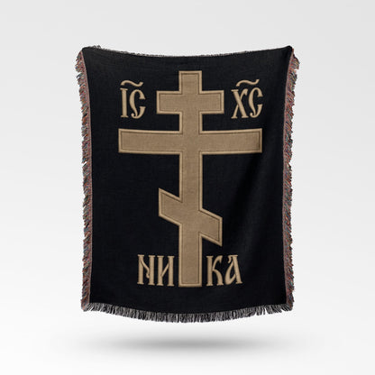 Black woven blanket with a gold Byzantine cross and Greek text "IC XC NIKA".