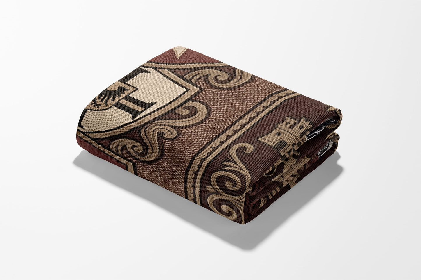 Folded throw blanket with ornate brown and tan crest and scroll pattern.