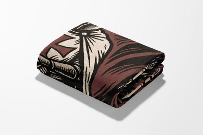 Folded blanket with a bold, graphic pattern in brown, cream, and black.