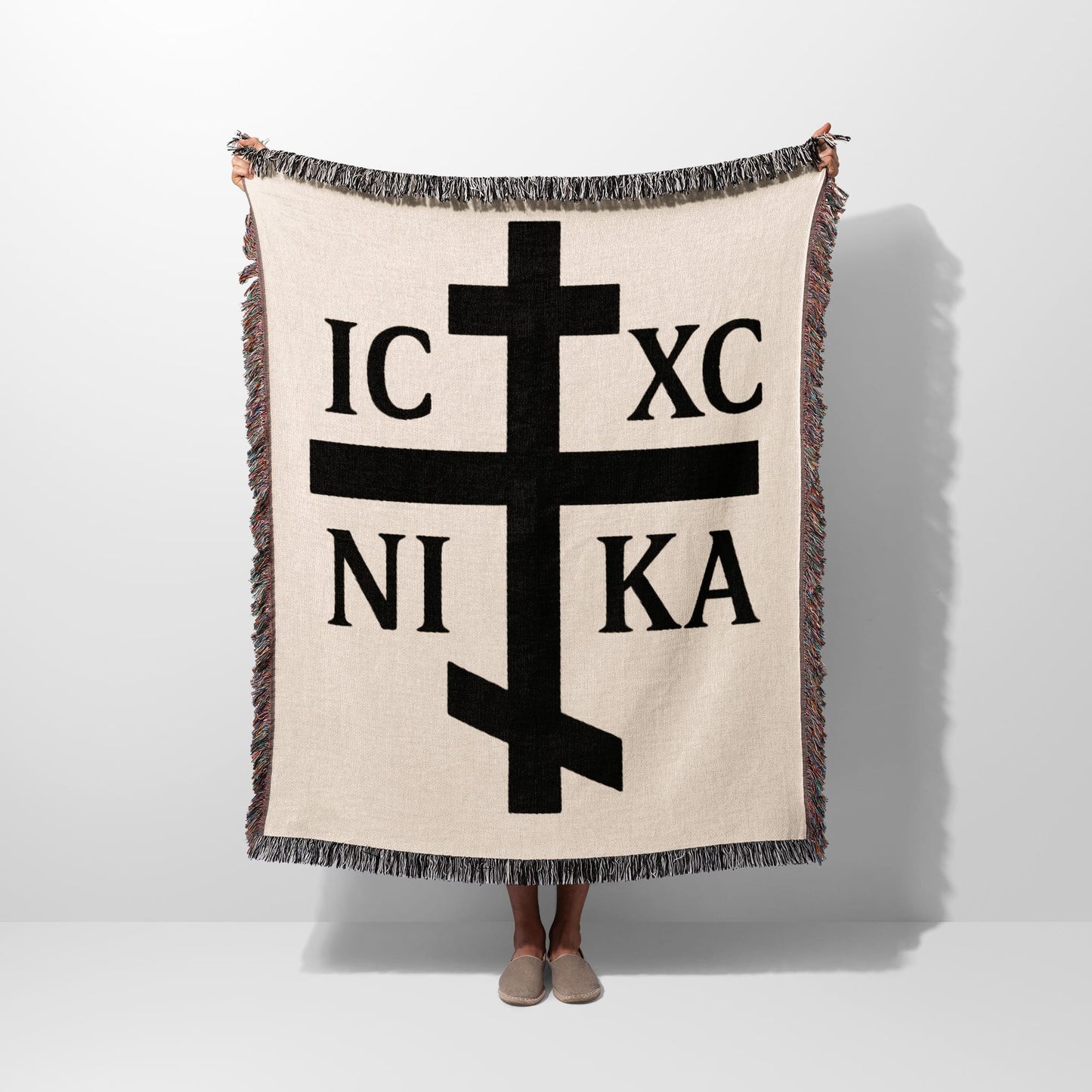 Cream woven blanket with black Orthodox Christian cross and Greek initials IC XC NI KA.