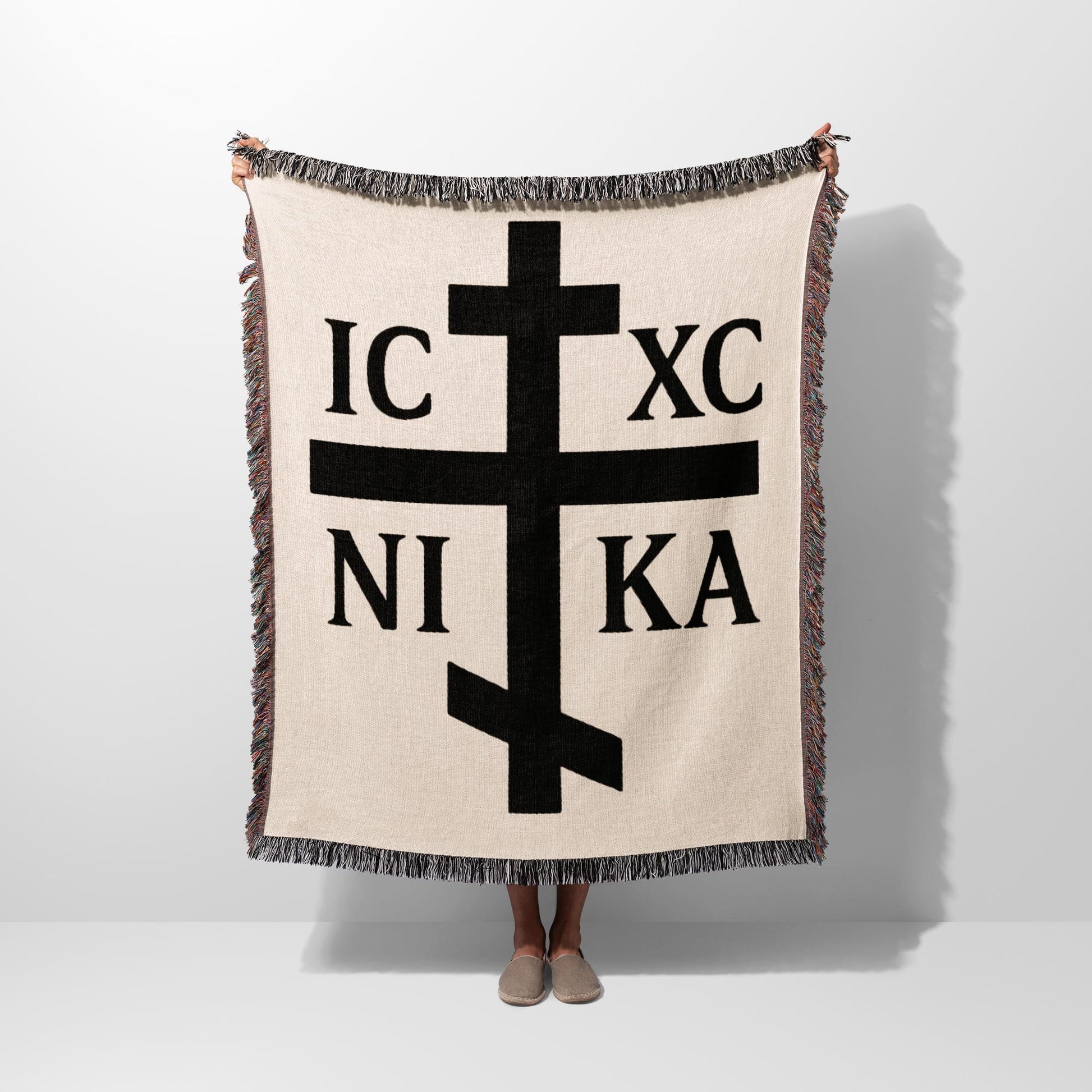 Cream woven blanket with black Orthodox Christian cross and Greek initials IC XC NI KA.