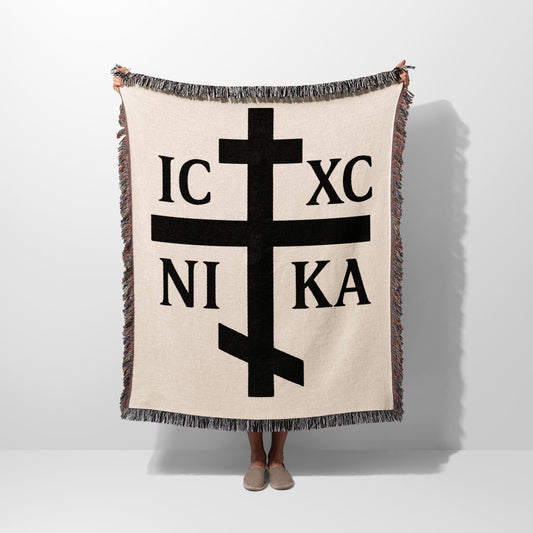 Cream woven blanket with black Orthodox Christian cross and Greek initials IC XC NI KA.