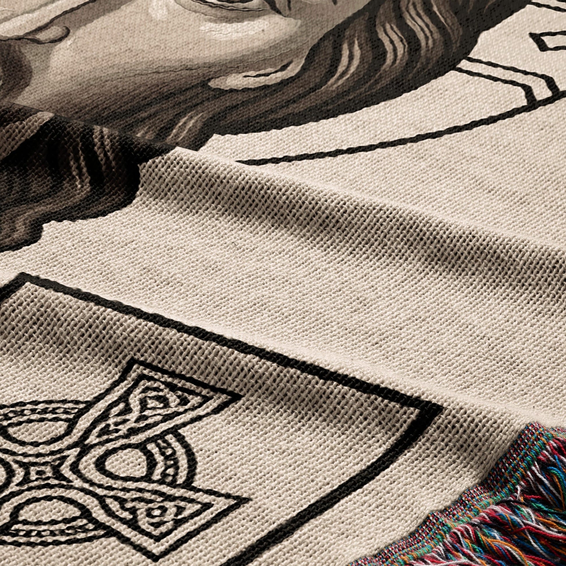 Knit blanket with Celtic knot design and portrait detail, fringed edge.