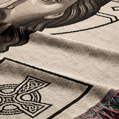 Knit blanket with Celtic knot design and portrait detail, fringed edge.