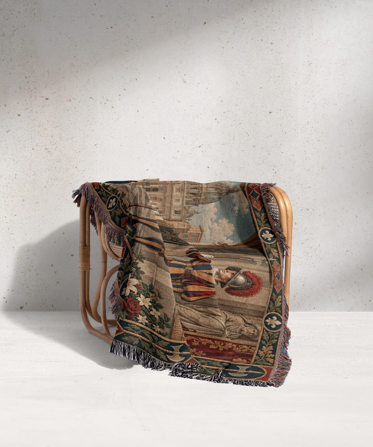 A woven throw blanket with a historical scene of a Swiss guard draped over a rattan armchair.