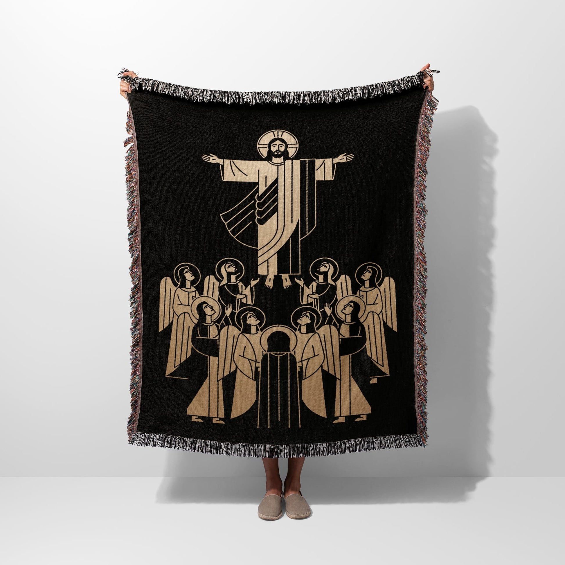 Jesus with open arms surrounded by angels on a black woven blanket.
