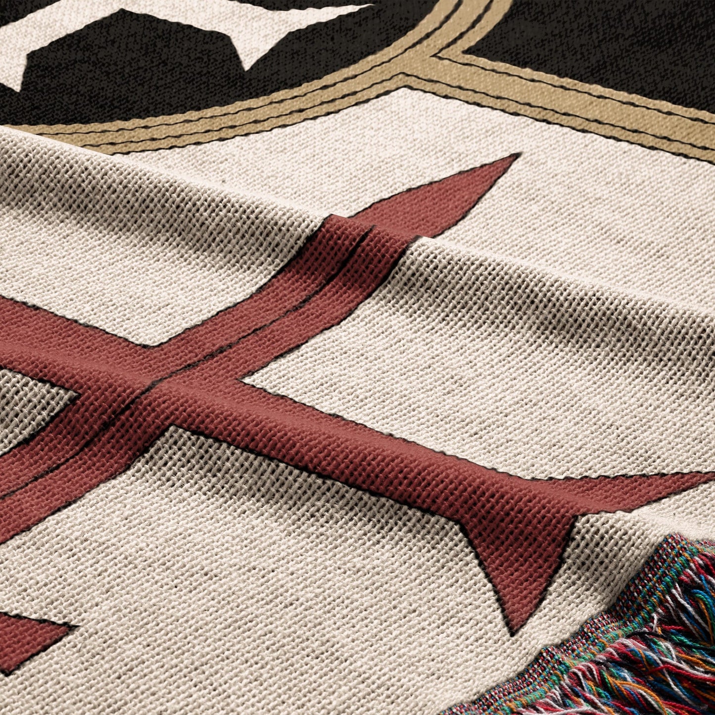 Cream blanket with red and black geometric pattern and fringed edge.