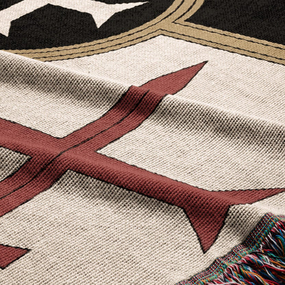 Cream blanket with red and black geometric pattern and fringed edge.