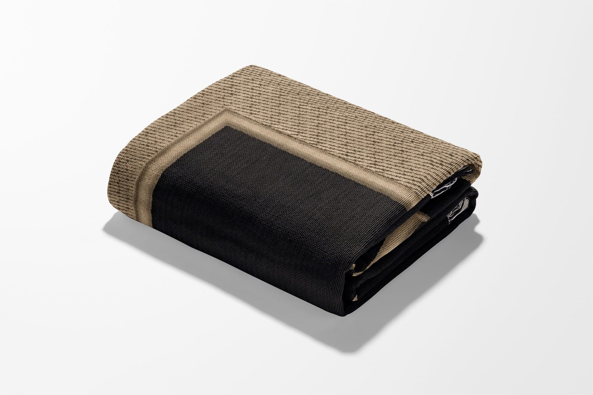 Folded beige and black patterned rug with a textured surface.