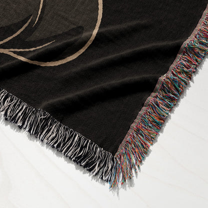 Black woven throw blanket with colorful fringe detail and a subtle pattern.