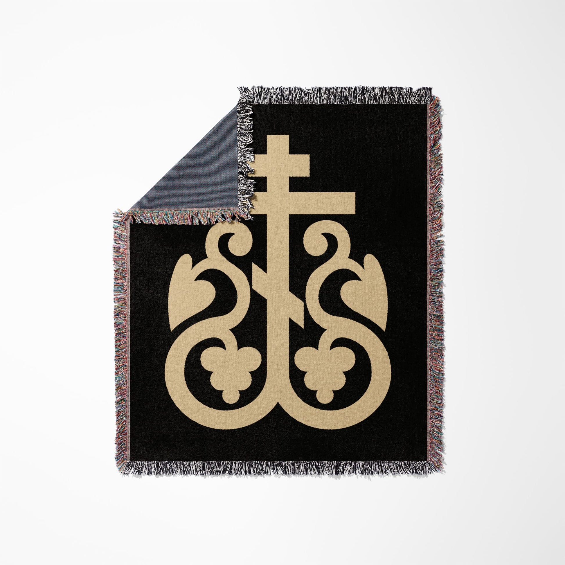 Black throw blanket with ornate beige cross design and fringed edges.