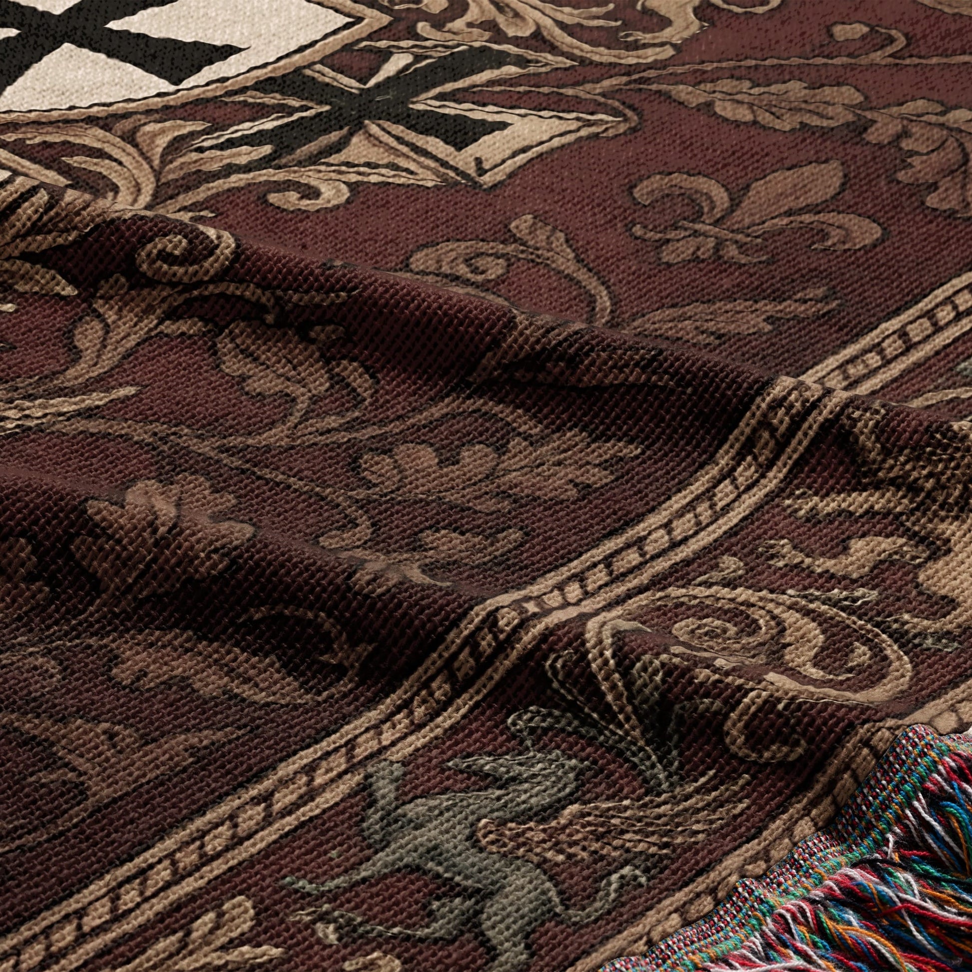 Brown woven blanket with ornate scrolling patterns, fleurs-de-lis, and a winged creature.