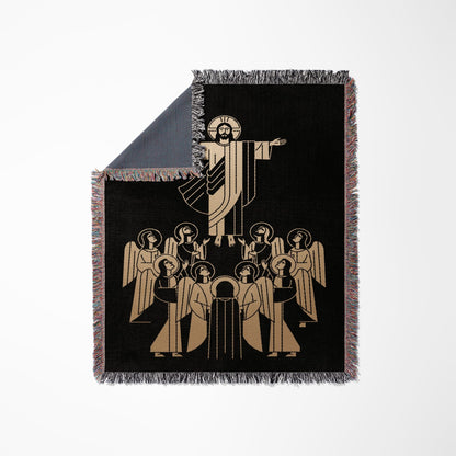 Jesus with outstretched arms surrounded by angels on a black woven throw blanket.