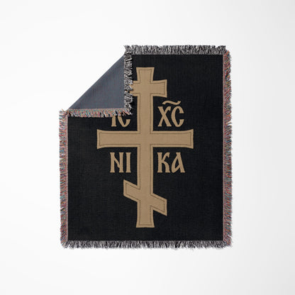 Black throw blanket with tan Orthodox Christian cross and Greek letters.