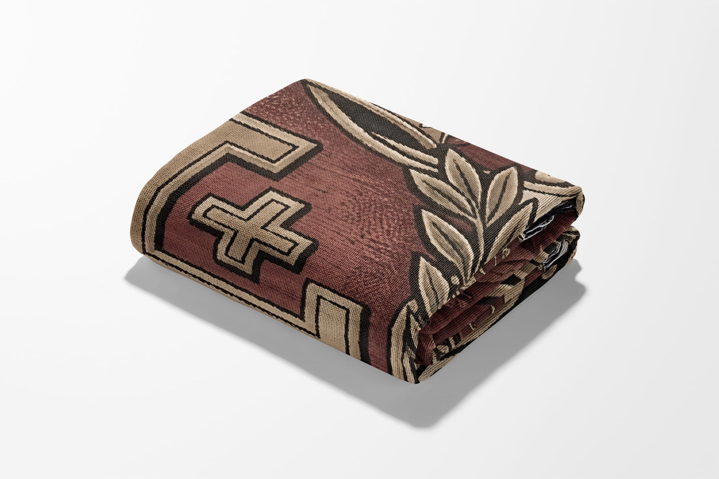 Folded blanket with geometric and floral patterns in red, beige, and black.