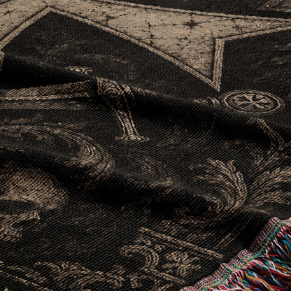 Black blanket with skull and cross motifs, fringed edge.