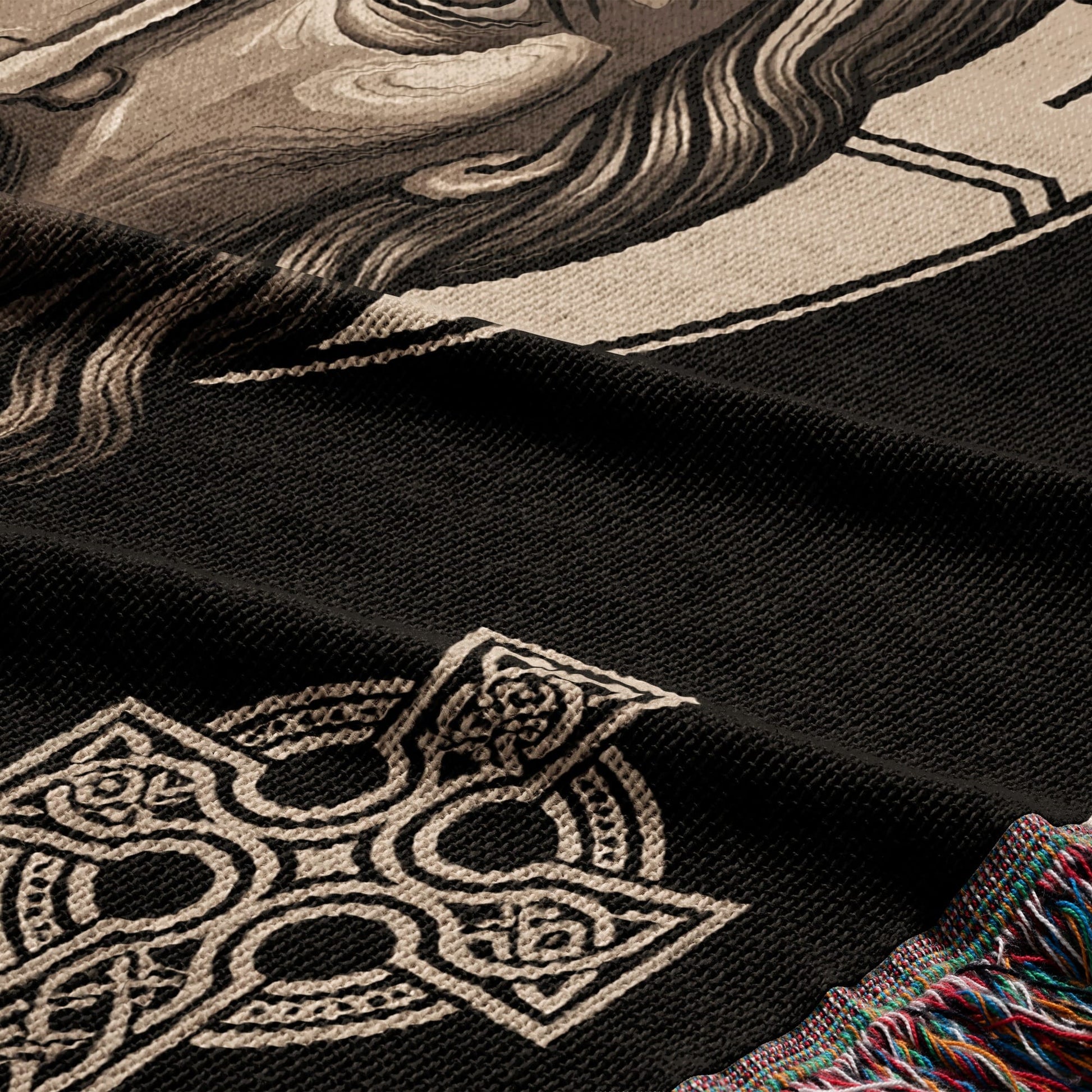 Black throw blanket with intricate Celtic knot design and detail of a person's face.