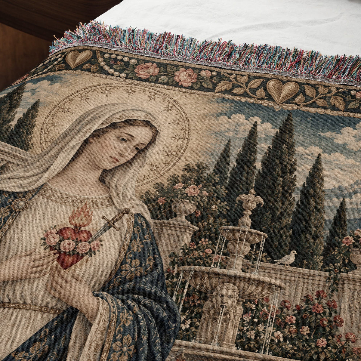 Woven tapestry throw blanket featuring the Immaculate Heart of Mary with a garden background and fringed edge.