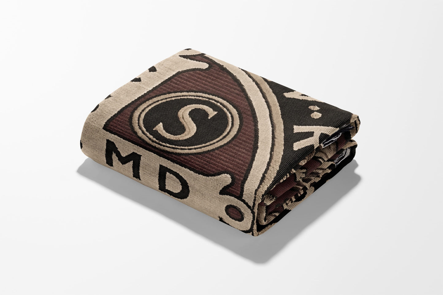 Rolled blanket with black, tan, and maroon geometric pattern and letters.