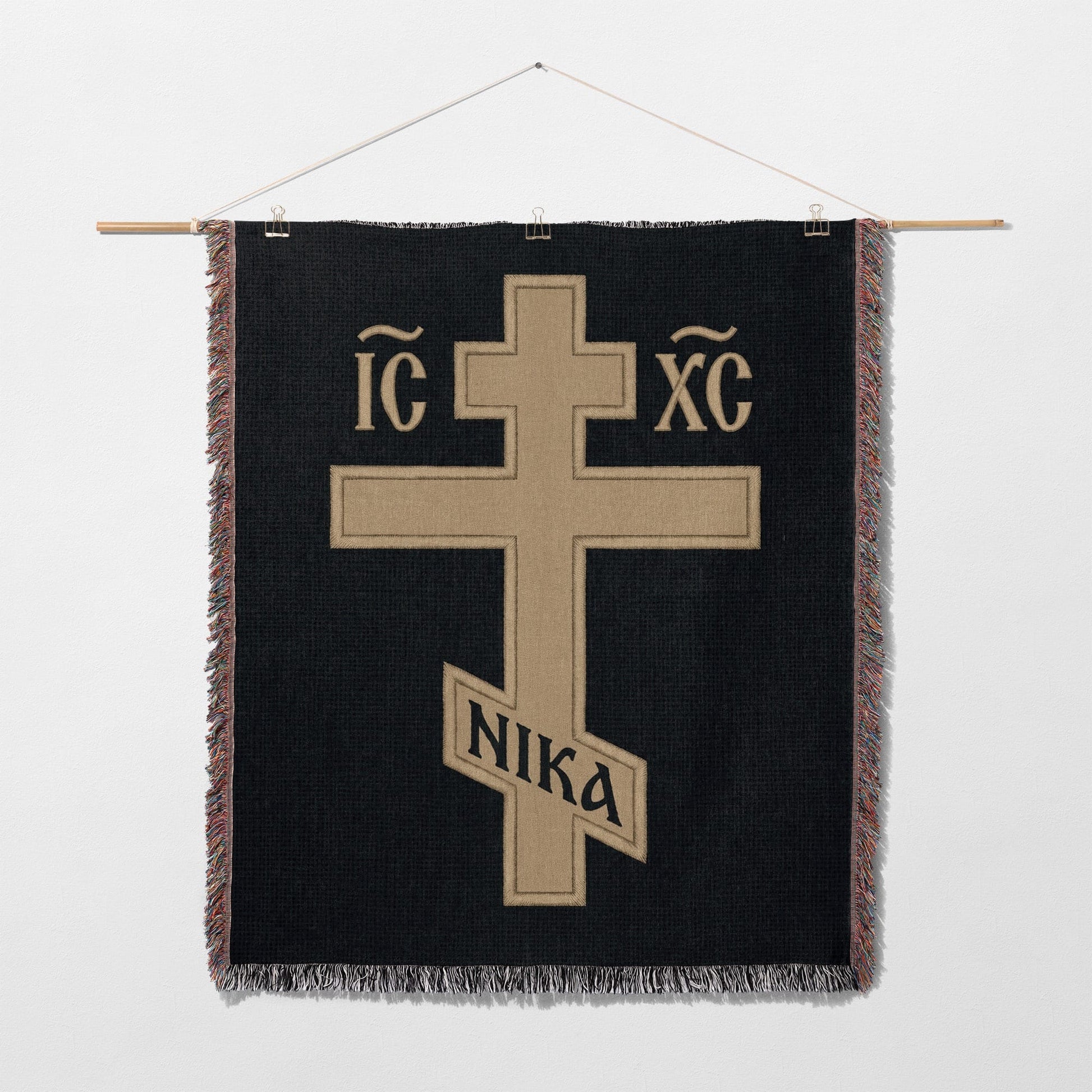 Cross with IC XC NIKA inscription on a black woven tapestry.